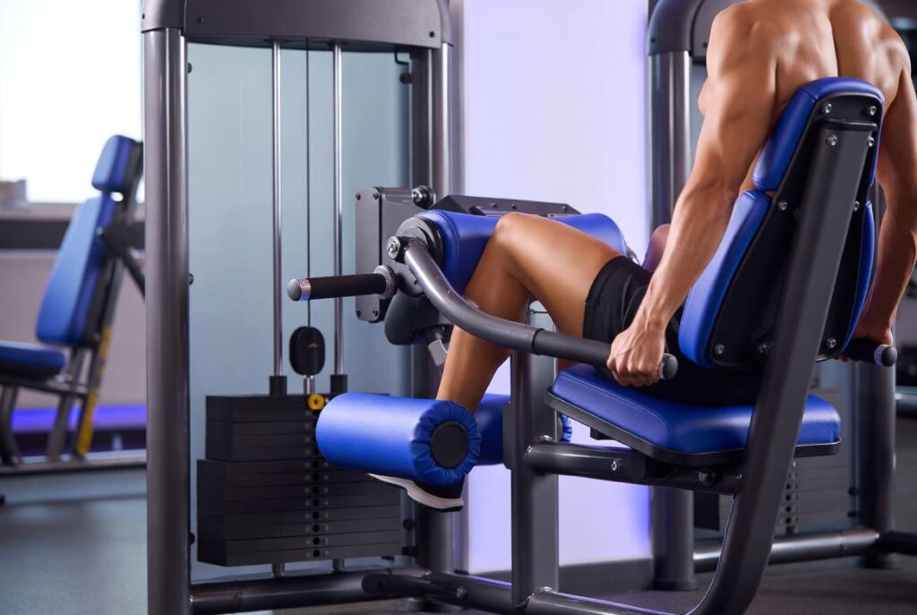 Athlete using a seated leg curl machine to isolate and strengthen the hamstring muscles