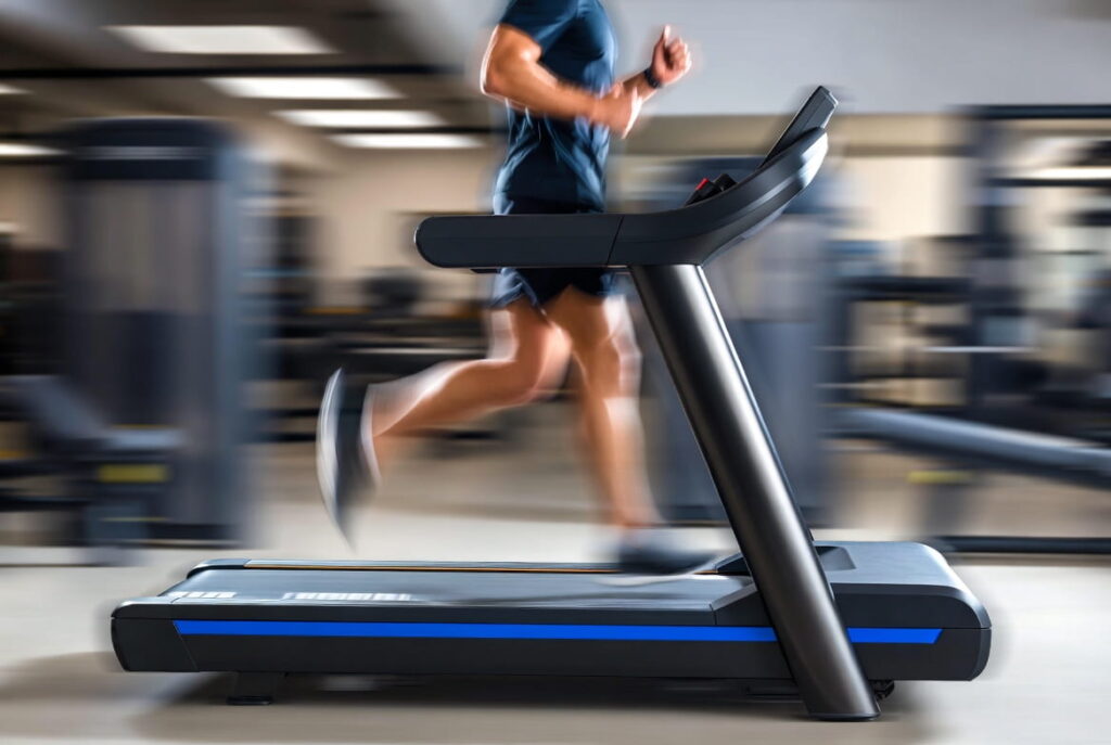 Athlete running on a treadmill in a gym, a high impact cardio machine for calorie burning