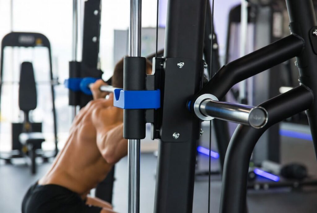 Athlete performing a guided squat on a Smith machine, a compound leg training machine with a fixed barbell