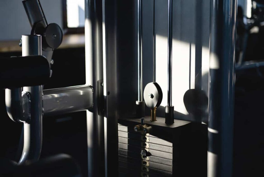 Close-up of a selectorized strength machine weight stack with adjustment pin