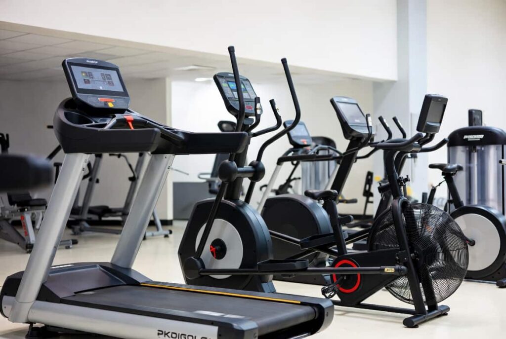 Row of cardio machines including treadmill, elliptical, and assault bike for effective weight loss workouts