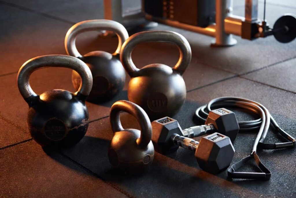 Kettlebells, dumbbells, and resistance bands used for strength training to support weight loss